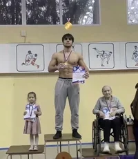 muscular-guy-on-a-podium-with-a-young-girl-and-an-elderly-woman.webp